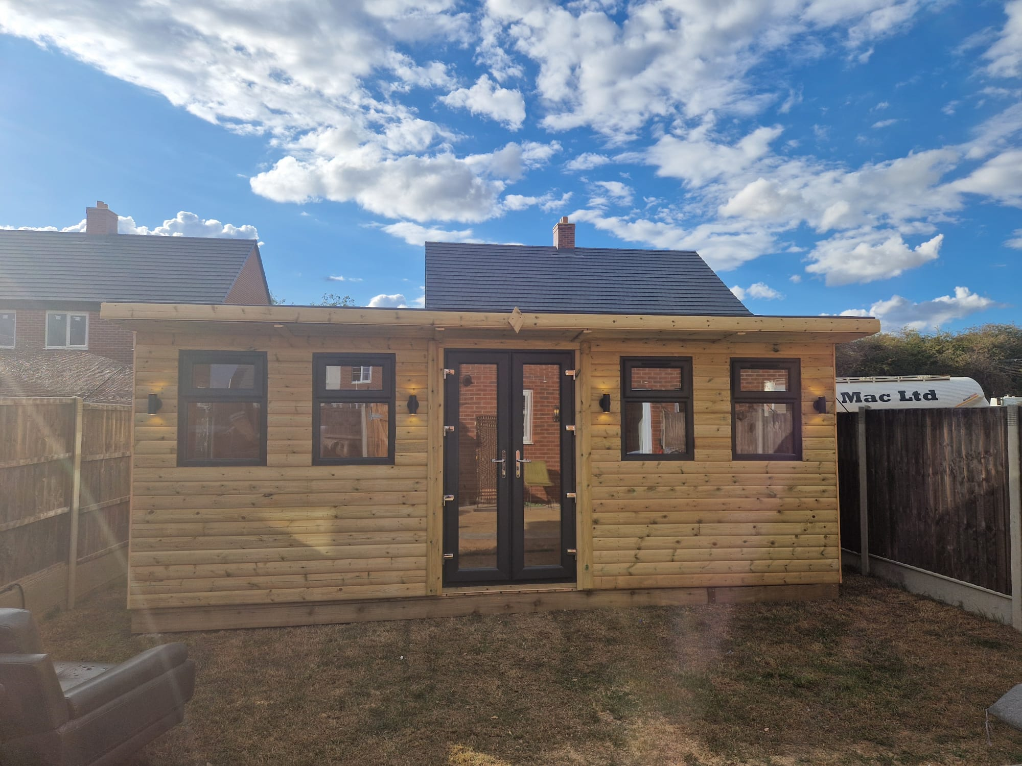 Modern garden building with timber frame multiple windows and professional landscaping