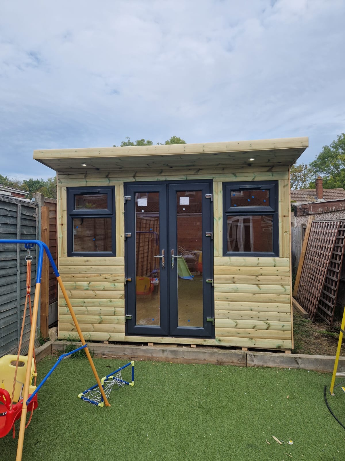 Contemporary timber garden room interior with wooden ceiling and lighting