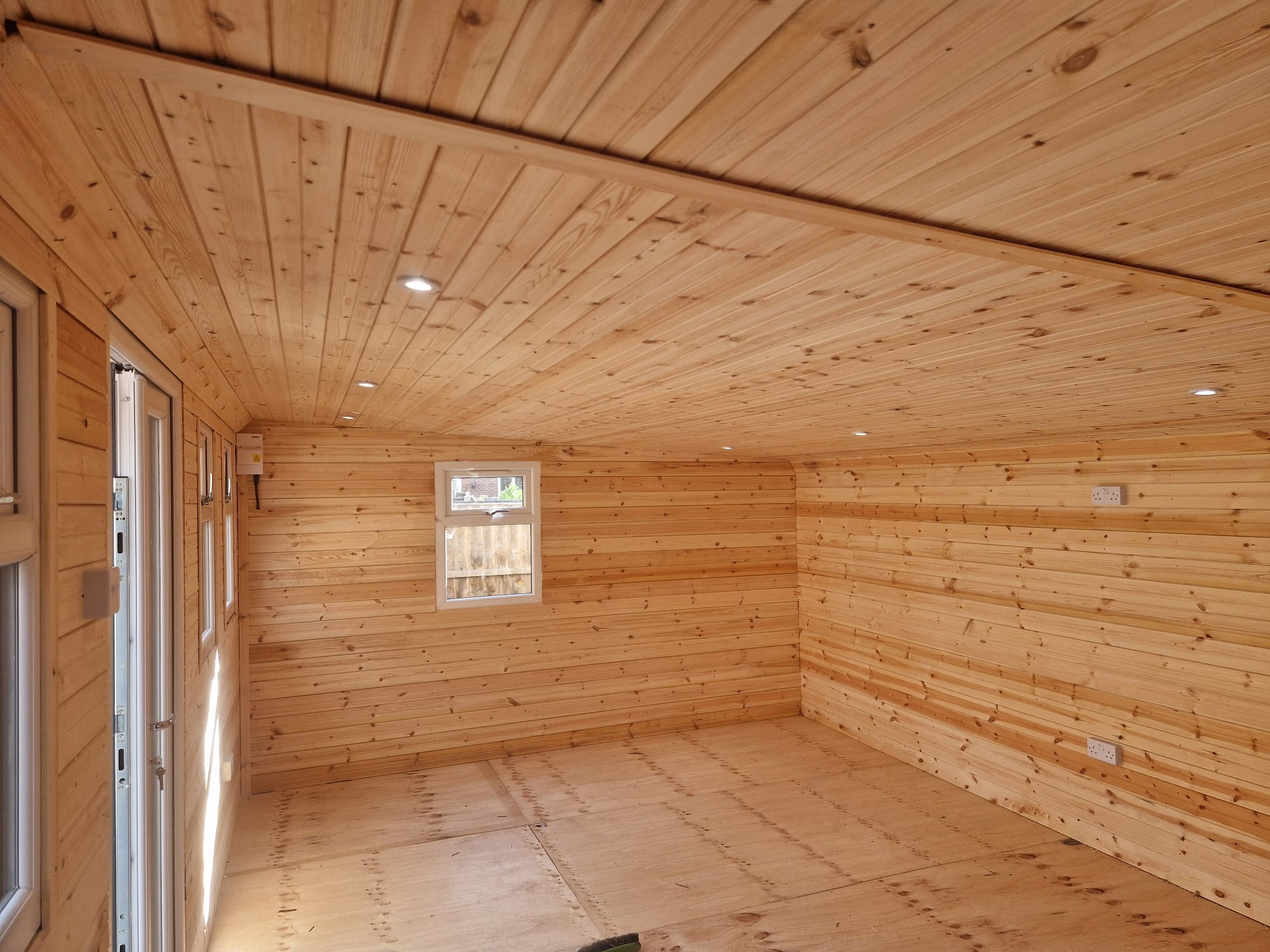 Garden studio building exterior with large windows and wooden cladding installation